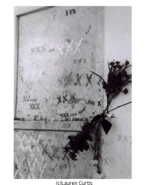35mm black and white photo of a close-up of the famous tomb of VooDoo priestess Marie Laveau, Louis Cemetery. French Quarter, new Orleans, Louisiana. Tomb is whitewashed with dried flowers and other offerings, triple X markings.