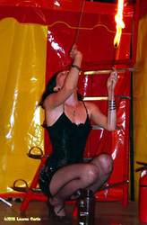 Photo of a female sword and fire swallower at a NJ carnival in a yellow and red tent.  Sideshow and circus performer.