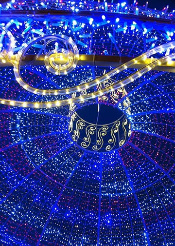 Bright blue and yellow Christmas lights in a giant lit up Christmas tree ball ornament. Holiday lights, festive.